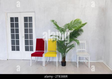 Chaises jaune blanc rouge fleur décorative dans une pièce lumineuse sur fond blanc Banque D'Images