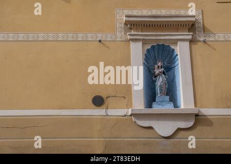 Sanctuaire votif dédié à la Vierge Marie avec l'enfant Jésus sur la façade d'un ancien palais dans le centre historique de finale Ligure, Savone, Ligurie Banque D'Images