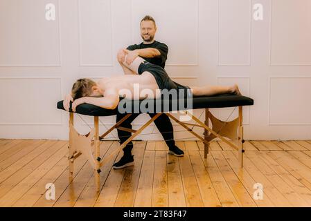 Homme détendu se remettant en massage avec chiropraticien professionnel. Concept de relaxation. thérapie manuelle, intérieur de la salle de massage, Banque D'Images