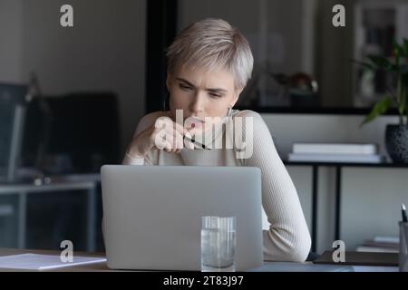 Concentré préoccupé fronçant les sourcils femme d'affaires concentré sur l'écran d'ordinateur portable Banque D'Images