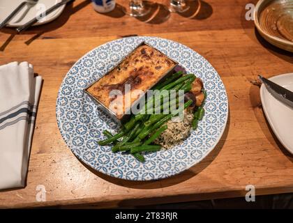 Lasagnes cuites avec haricots verts et riz servi sur une assiette en céramique dans le restaurant méditerranéen Banque D'Images