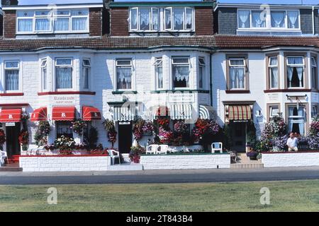 Paniers suspendus colorés de fleurs le long d'une rangée de maisons d'hôtes. Trafalgar Road, Great Yarmouth, Norfolk, Angleterre, Royaume-Uni Banque D'Images