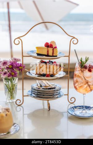 Ensemble de cheesecake, pain grillé au miel et boisson servi dans le stand de gâteau sur la table dans le café de bord de mer Banque D'Images