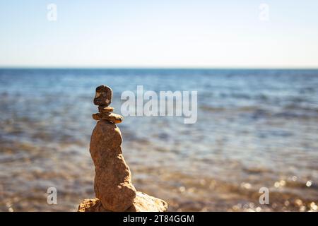 Pyramide de galets de mer sur une plage de sable ensoleillé. Le concept d'équilibre de vie et d'harmonie sur la droite, il y a une place pour une inscription. Haute qualité Banque D'Images