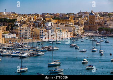 Les eaux calmes et les bateaux entourant les trois villes en face de la Valette à Malte - Kalkara Village Parish Church Silver Dome Buildings Banque D'Images