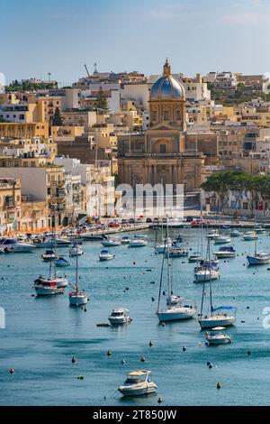 Les eaux calmes et les bateaux entourant les trois villes en face de la Valette à Malte - Kalkara Village Parish Church Silver Dome Buildings Banque D'Images