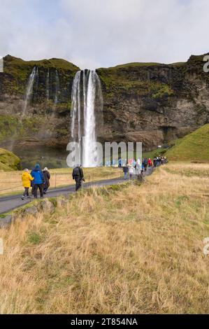 Touristes marchant le long d'un chemin vers Seljalandsfoss cascade, Islande Banque D'Images