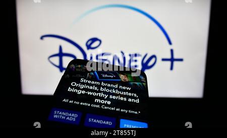 Téléphone mobile avec le site Web du service américain de streaming vidéo à la demande Disney plus devant le logo de l'entreprise. Effectuez le focus sur le coin supérieur gauche de l'écran du téléphone. Banque D'Images