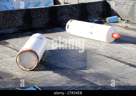 Les bouteilles de gaz sont couchées sur le toit d'une maison pendant qu'elles travaillent Banque D'Images