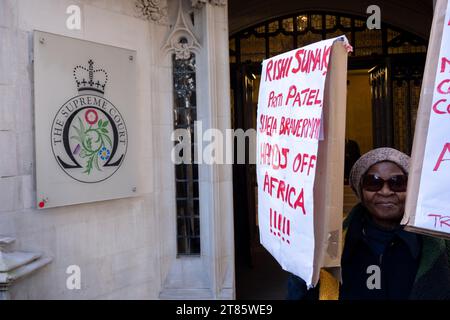 Des manifestants portant des pancartes attendent devant la Cour suprême l'annonce de la décision concernant le projet britannique d'envoyer des immigrants au Rwanda le 15 novembre 2023 à Londres, Royaume-Uni. Peu de temps après, portant un coup dur au gouvernement conservateur, la décision a été annoncée que le Royaume-Uni ne pouvait pas envoyer de demandeurs d’asile au Rwanda et que c’était illégal. Banque D'Images