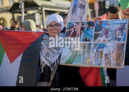 Turin, Italie. 18 novembre 2023. Une femme portant un hijab à côté du drapeau palestinien montre une pancarte avec des photographies d’enfants blessés, lors de manifestations en faveur de la Palestine à Turin. "Vie, terre, liberté pour le peuple palestinien. Sauvons Gaza'' est le slogan de l'Association palestinienne italienne affiché sur la bannière à la tête de la marche organisée par la communauté palestinienne de Turin, à laquelle ont participé plusieurs centaines de personnes. (Image de crédit : © Marcello Valeri/ZUMA Press Wire) USAGE ÉDITORIAL SEULEMENT! Non destiné à UN USAGE commercial ! Banque D'Images