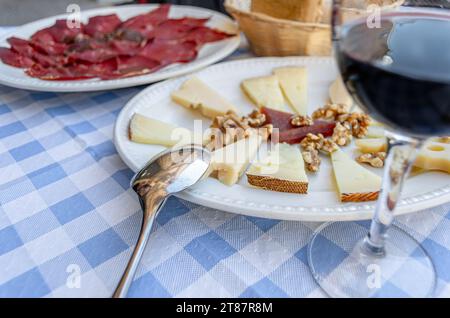 Table avec des tapas espagnoles typiques de Castilla y Leon, avec du fromage, de la charcuterie Leon (cecina) et un verre de vin Banque D'Images