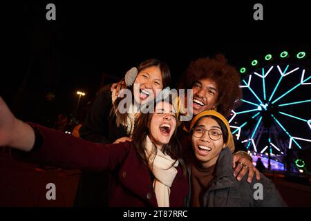 Selfie téléphone groupe multiracial de collègues heureux ayant du plaisir en hiver. Jeune génération souriante z. Banque D'Images