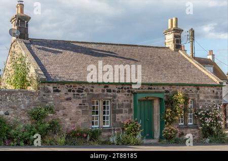 Cottage écossais avec des roses autour de la porte d'entrée abritée qui est peinte en vert Banque D'Images