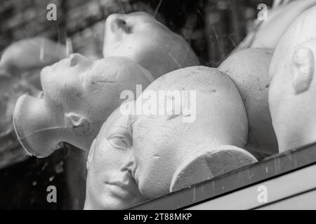 Un groupe de têtes de mannequin dans une vitrine de magasin Banque D'Images