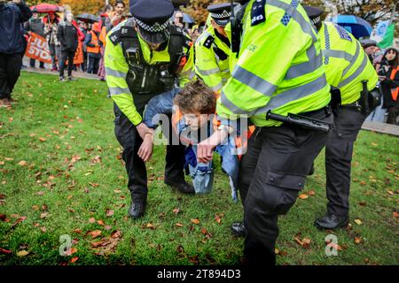 Londres, Royaume-Uni. 18 novembre 2023. Un manifestant est arrêté pour violation des conditions de libération sous caution par le London Eye. Il suffit d'arrêter la marche du pétrole à travers Londres pour souligner la nécessité de changer la façon dont nous dépendons du pétrole et du gaz pour l'énergie. Ils soutiennent que le temps presse pour la planète et que le changement immédiat des combustibles fossiles est nécessaire. Ils affirment que le gouvernement emprisonne les manifestants pacifiques et protège les vrais criminels, les récompensant en autorisant plus de 100 nouveaux projets pétroliers et gaziers. Crédit : SOPA Images Limited/Alamy Live News Banque D'Images