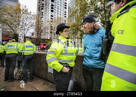 Londres, Royaume-Uni. 18 novembre 2023. Un manifestant est arrêté et menotté après avoir bloqué les routes avec sa bannière. Il suffit d'arrêter la marche du pétrole à travers Londres pour souligner la nécessité de changer la façon dont nous dépendons du pétrole et du gaz pour l'énergie. Ils soutiennent que le temps presse pour la planète et que le changement immédiat des combustibles fossiles est nécessaire. Ils affirment que le gouvernement emprisonne les manifestants pacifiques et protège les vrais criminels, les récompensant en autorisant plus de 100 nouveaux projets pétroliers et gaziers. (Photo Martin Pope/SOPA Images/Sipa USA) crédit : SIPA USA/Alamy Live News Banque D'Images