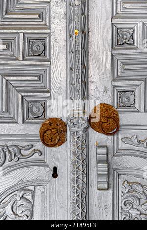 Porte en bois gris antique avec poignées en fer. Monastère Sainte Croix dans le village d'Omodos. Chypre Banque D'Images