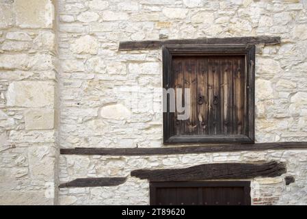 Fenêtres en bois fantaisie dans le mur de pierre du village chypriote d'Omodos Banque D'Images