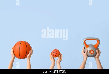 Mains féminines avec des balles pour jouer au basket-ball et kettlebell sur fond bleu Banque D'Images