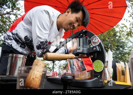 Un barista thaïlandais en bord de route tire une dose d'espresso à l'aide d'une presse à levier portable à Chiang Mai le 17 février 2023. Banque D'Images