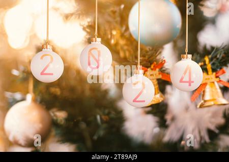 Décorez l'arbre à l'intérieur de votre maison avec une boule de Noël au crépuscule pour célébrer Noël et accueillir la nouvelle année 2024. Banque D'Images