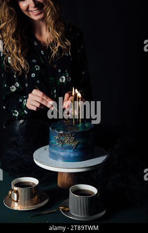 femme coupe le gâteau pour les vacances deux tasses de café délicieux desserts bonbons Banque D'Images