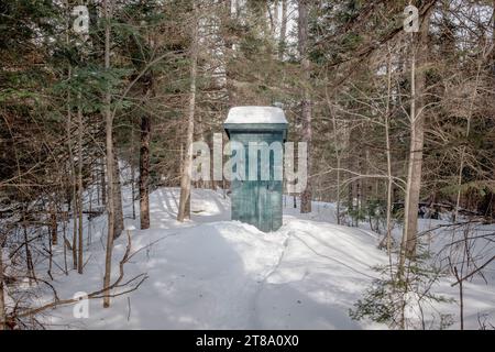 Une toilette extérieure dans le bois en hiver pris sur une journée ensoleillée d'hiver à Mont Tremblant, Québec, Canada Banque D'Images