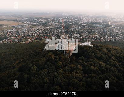 Photo aérienne de la tour de l'émetteur sur la colline de Zobor à Nitra - Slovaquie. Vol en drone au-dessus de la colline et grande ville près de la forêt. Banque D'Images