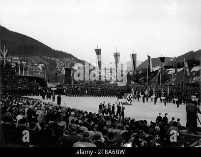 Caméraman en bas à droite filmant la Parade d'ouverture des IVes JEUX OLYMPIQUES D'HIVER à GARMISCH - PARTENKIRCHEN à partir du 6e. au 16 février 1936 pour le court métrage documentaire JUGEND DER WELT / YOUTH OF THE WORLD (sorti en 1936) les réalisateurs HERBERT BRIEGER et CARL JUNGHANS Propaganda - Ausschuss fur die Olympische Spiele (Berlin) / Reichsministerium fur Volksaufklarung und Propaganda Reichspropagandaleitung der NSDAP Banque D'Images