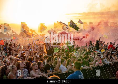 Photo de dossier datée du 24/06/23 de la foule regardant Fred à nouveau sur l'autre scène alors que le soleil se couche sur le festival de Glastonbury à Worthy Farm dans le Somerset. Les billets standard pour le Festival de Glastonbury 2024 ont été vendus en moins d'une heure, ont confirmé les organisateurs. Date d'émission : dimanche 19 novembre 2023. Banque D'Images