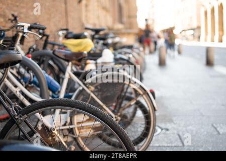 Ensemble de vélos garés sur la rue en rangée avec fond de route flou Banque D'Images