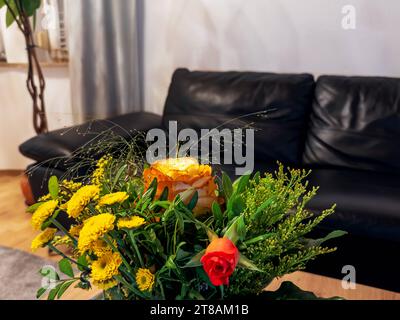 Augsbourg, Bavière, Allemagne - 14 novembre 2023 : bouquet de fleurs fraîches sur une table dans un salon avec un canapé en arrière-plan *** frischer Blumenstrauß auf einem Tisch in einem Wohnzimmer mit einem sofa im hintergrund crédit : Imago/Alamy Live News Banque D'Images