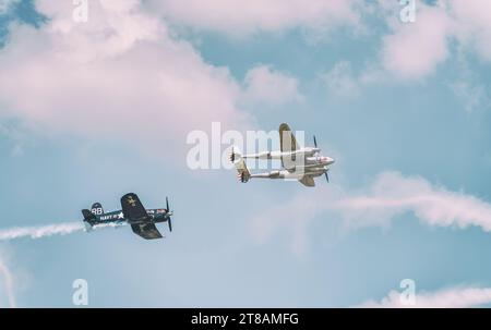 Bucarest, Roumanie - mai 2023 : les avions de guerre LOCKHEED P-38 LIGHTNING et chance Vought F4U Corsair font partie de la flotte Flying Bulls volant contre t Banque D'Images