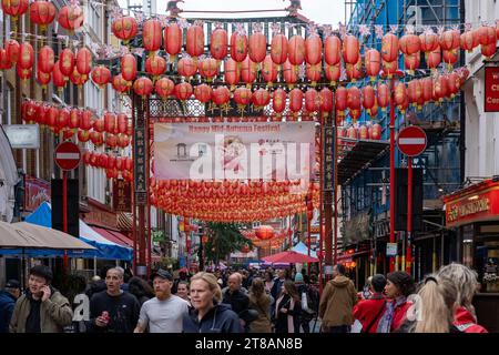 En regardant vers le bas de la rue Gerrard dans China Town, animée par les touristes et les acheteurs. Les lanternes chinoises pendent d'en haut. Soho, centre de Londres. Banque D'Images