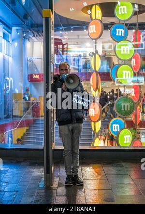 Un homme avec un mégaphone se tient à Leicester Square tenant un panneau disant "les humains sont stupides" - le centre de Londres, la liberté d'expression, des spectacles de rue drôles. Banque D'Images