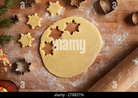 Découpe des formes d'étoiles de pâte roulée pour préparer des biscuits de Noël Linzer maison, vue de dessus Banque D'Images