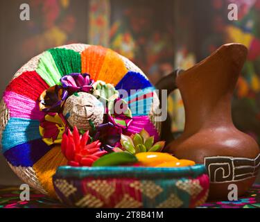 Panier traditionnel mexicain tissé, piments Chili, avocat et cruche traditionnelle traditionnelle rustique en argile Jarritos sur fond floral mexicain Banque D'Images