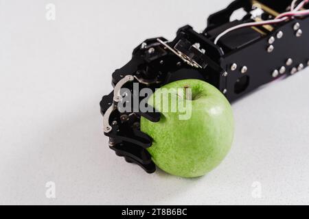 Main de vrai robot avec pomme verte. Concept de développement d'intelligence artificielle et d'automatisation de processus robotisés. Banque D'Images
