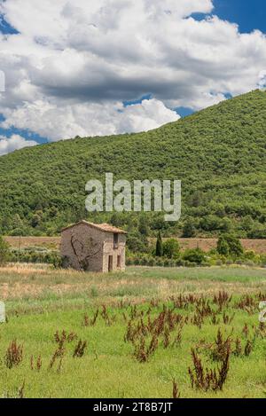 Ferme unique apparemment abandonnée construite en pierre au milieu d'un champ agricole rural Banque D'Images