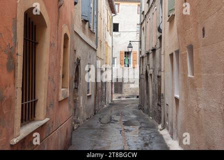 Ruelles latérales étroites dans le centre-ville historique de Manosque, France par un jour nuageux et pluvieux Banque D'Images