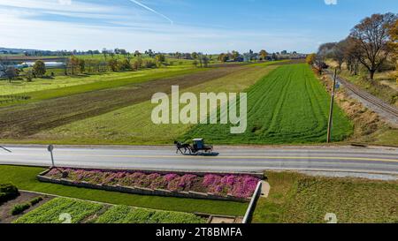 Une vue aérienne d'un cheval Amish Pick Up et d'un buggy voyageant sur une route de campagne rurale, Thru Farm Fields par un jour d'automne ensoleillé Banque D'Images