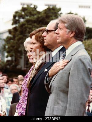 **PHOTO DE FICHIER** Rosalynn carter est décédé. Le président américain Jimmy carter, la droite et la première dame Rosalynn carter, au centre gauche et le premier ministre Raymond barre de France, au centre droit, et son épouse, Eve barre, à gauche, tenez-vous à l'attention lors de la cérémonie d'arrivée en plein honneur sur la pelouse sud de la Maison Blanche à Washington, DC le 15 septembre 1977. Le Premier ministre barre est à Washington pour deux jours de pourparlers avec les hauts fonctionnaires de l'administration carter. Crédit : Arnie Sachs/CNP/MediaPunch Banque D'Images