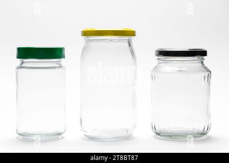 Bocaux en verre transparent vides avec couvercles isolés sur fond blanc Banque D'Images