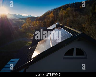 Vivez une vie durable avec des panneaux photovoltaïques sur le toit d'une résidence privée, capturée à partir d'une perspective captivante de drone à la veille chaude Banque D'Images