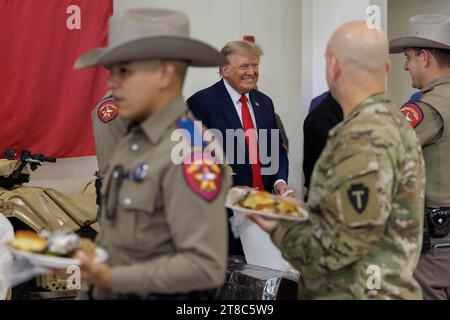 Edinburg, Texas, États-Unis. 19 novembre 2023. L'ancien président DONALD TRUMP sert des repas aux soldats du ministère de la sécurité publique du Texas (DPS) à l'aéroport international du Texas du Sud le 19 novembre 2023 à Edinburg, Texas. Trump et le gouverneur Greg Abbott ont servi des repas à la Garde nationale du Texas et aux Texas DPS Troopers qui sont stationnés à la frontière entre les États-Unis et le Mexique pendant les vacances de Thanksgiving. Crédit : ZUMA Press, Inc./Alamy Live News Banque D'Images