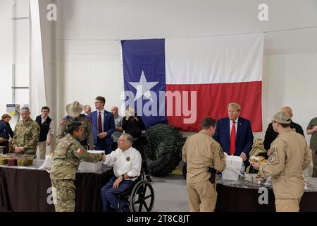 Edinburg, Texas USA, novembre 19 2023:. L'ancien président DONALD TRUMP et le gouverneur du Texas GREG ABBOTT aident à servir un repas de vacances tôt aux soldats du ministère de la sécurité publique du Texas (DPS) et aux membres de la garde nationale du Texas stationnés à la frontière entre les États-Unis et le Mexique pendant les vacances de Thanksgiving. Photo de Michael Gonzalez/Pool Banque D'Images