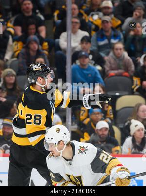 Pittsburgh, États-Unis. 19 novembre 2023. Le défenseur des Penguins de Pittsburgh Marcus Pettersson (28) frappe le palet hors des airs au-dessus du centre des Golden Knights de Vegas Brett Howden (21) lors de la troisième période au PPG Paints Arena à Pittsburgh le dimanche 19 novembre 2023. Photo de Archie Carpenter/UPI. Crédit : UPI/Alamy Live News Banque D'Images