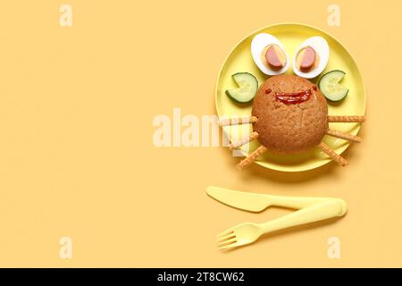 Assiette avec le petit déjeuner drôle des enfants en forme de crabe sur fond jaune Banque D'Images