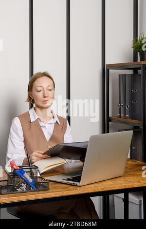 Jeune femme adulte tenant dans les mains classeur dossier avec des dossiers Banque D'Images